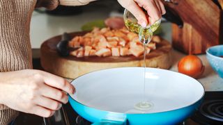 woman pouring cooking oil into a pan