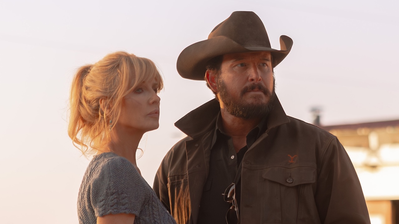 Beth and Rip standing together outside in the sunlight in Dutton Ranch Season 1