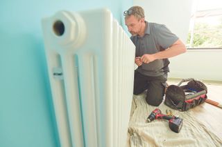 Plumber fitting radiator in house