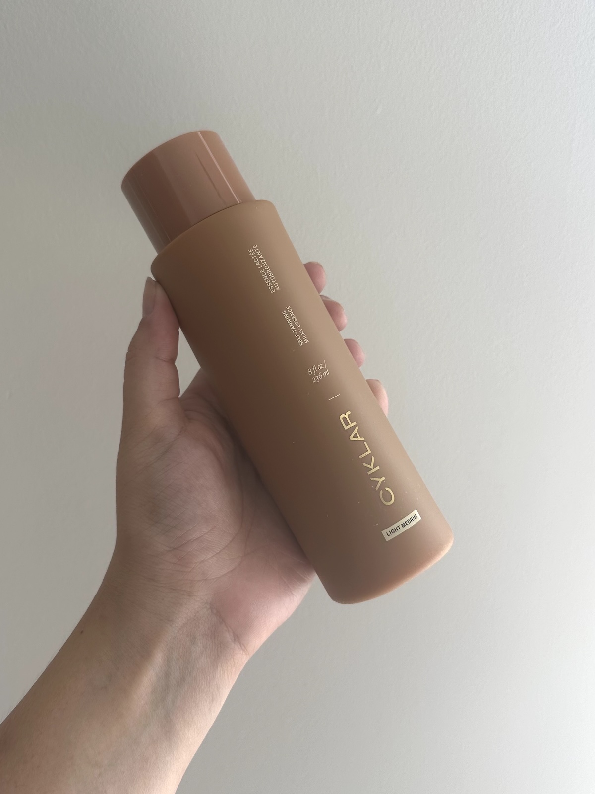 Beauty editor Kaitlyn McLintock holding Cyklar's self tanner