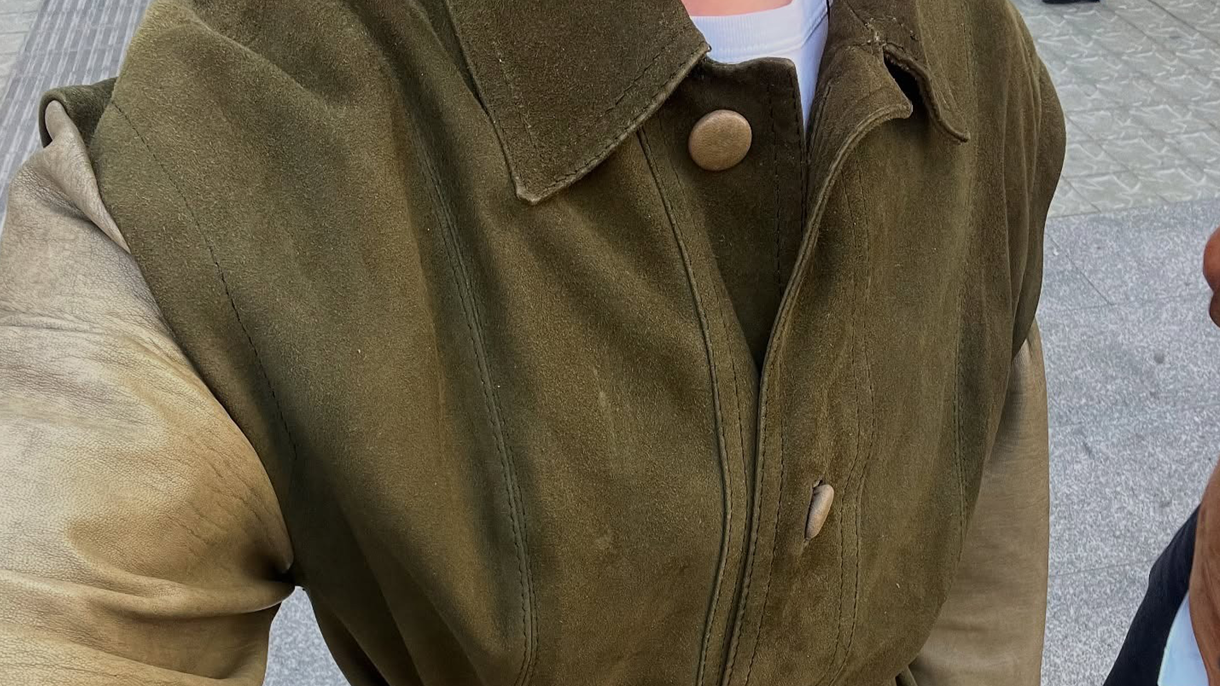 Madrid woman wearing olive green suede jacket.