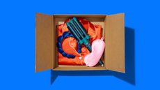 A box filled with PJs, sleep mask and other items on a blue background.