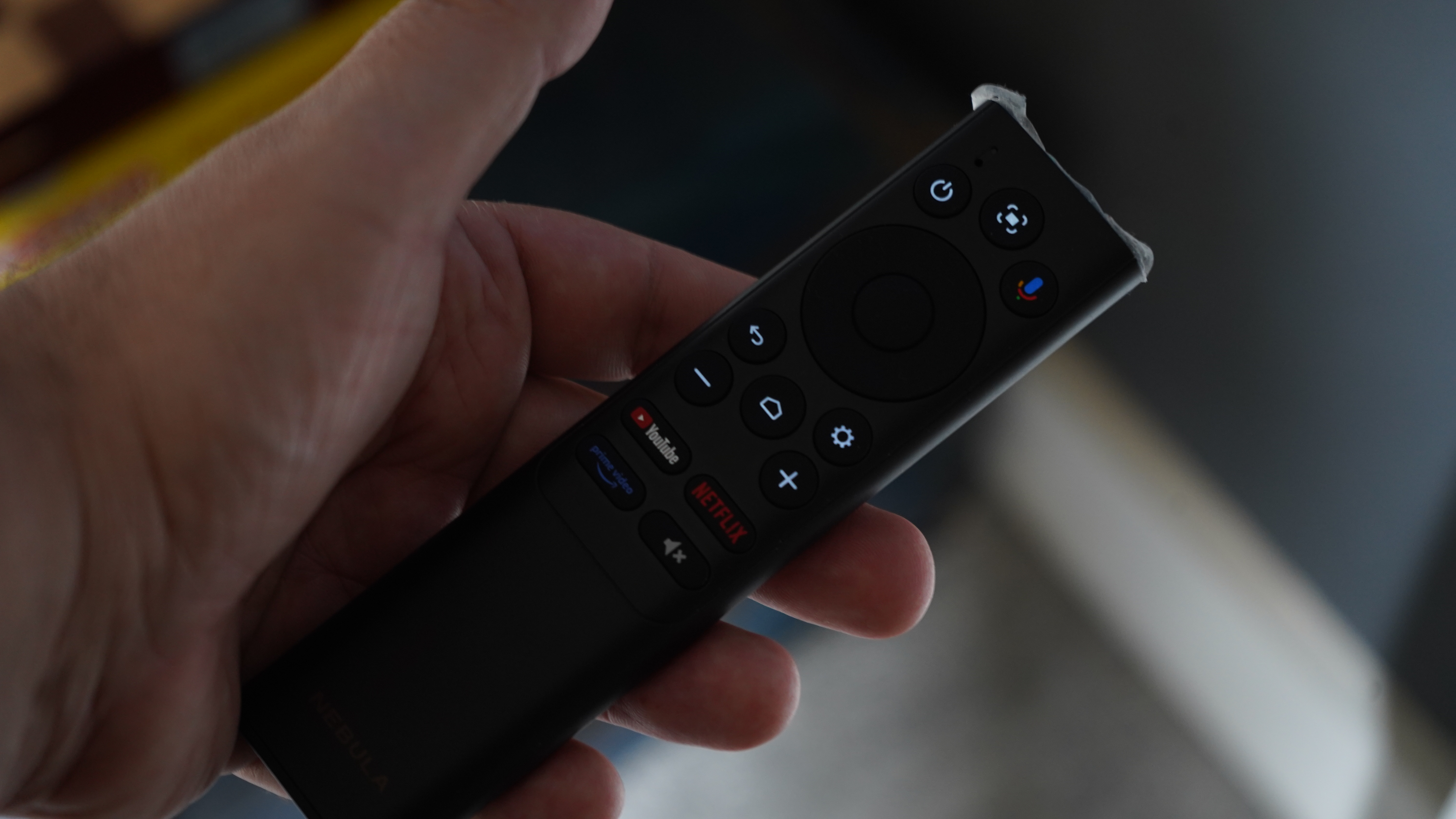 Nebula Cosmos 4K SE projector remote in hand