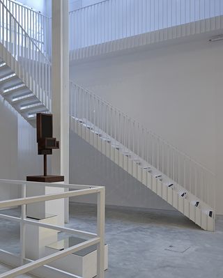 minimalist staircase within white gallery interior at Maison Colbert