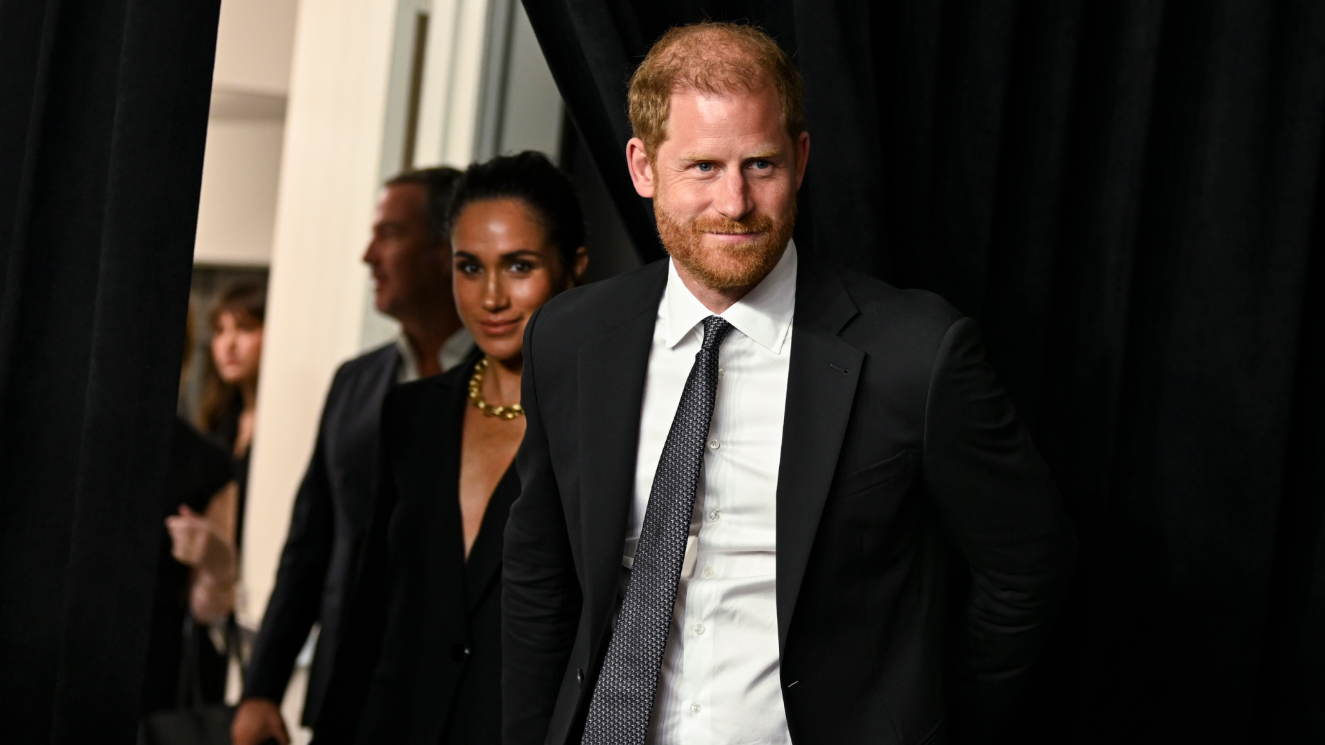 Meghan Markle and Prince harry wearing black suits