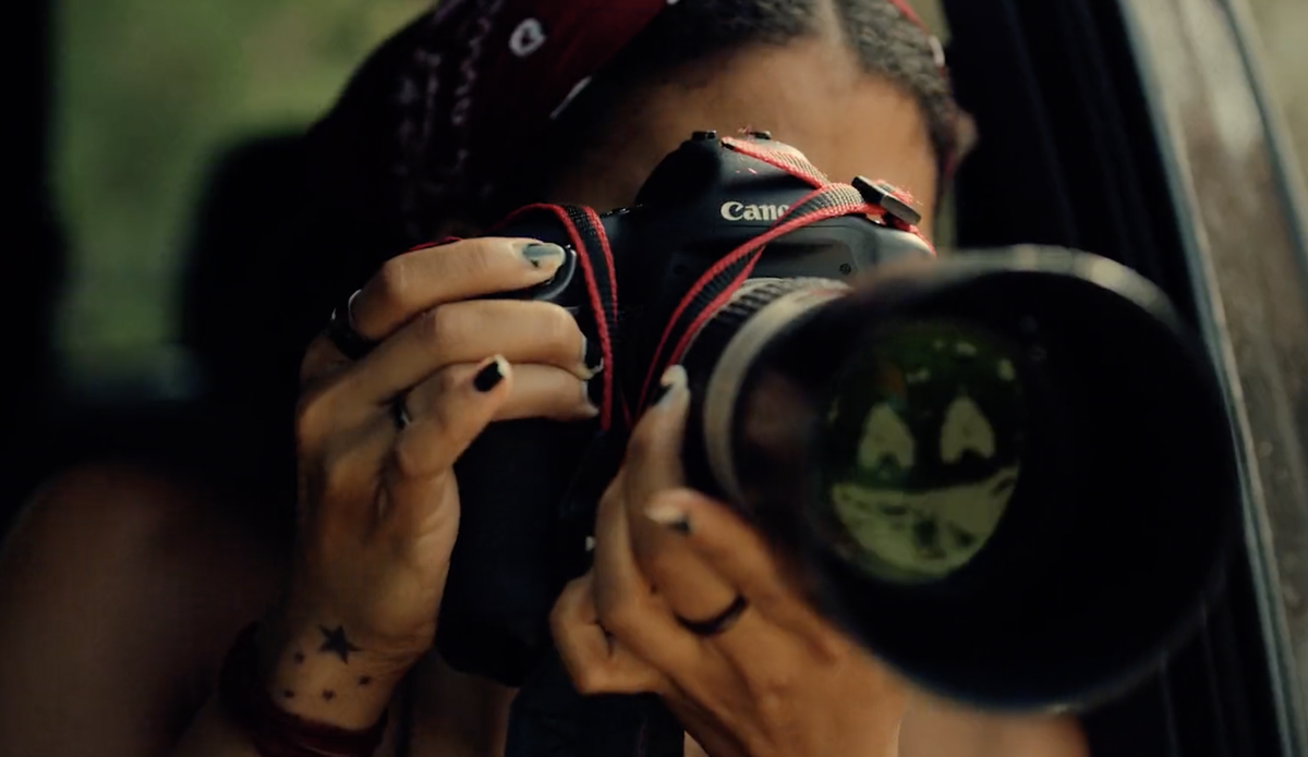 Black Mirror season 6: a woman taking a photo with the Black Mirror smile icon reflected in the lens