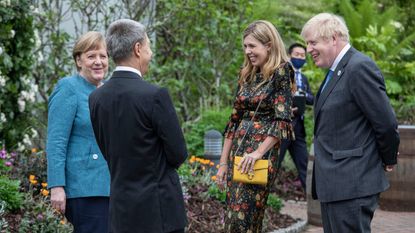 Germany's Chancellor Angela Merkel (L) and her husband, Joachim Sauer (2nd L) speak to Britain's Prime Minister Boris Johnson (R) and his wife Carrie Johnson at a reception with G7 leaders at The Eden Project in south west England on June 