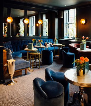 Dark navy barstools, and a wood burning stove Quo Vadis — London, UK