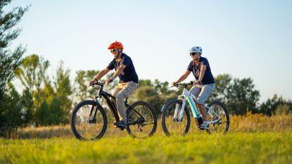 Two people riding electric bikes