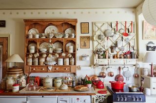 kitchen filled with antique chinaware and freestanding cabinetry