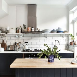 kitchen with white tiles and black cabinetry and an extractor fan