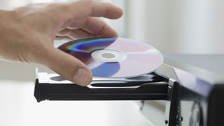Best DVD players 2022: image shows hand and DVD 