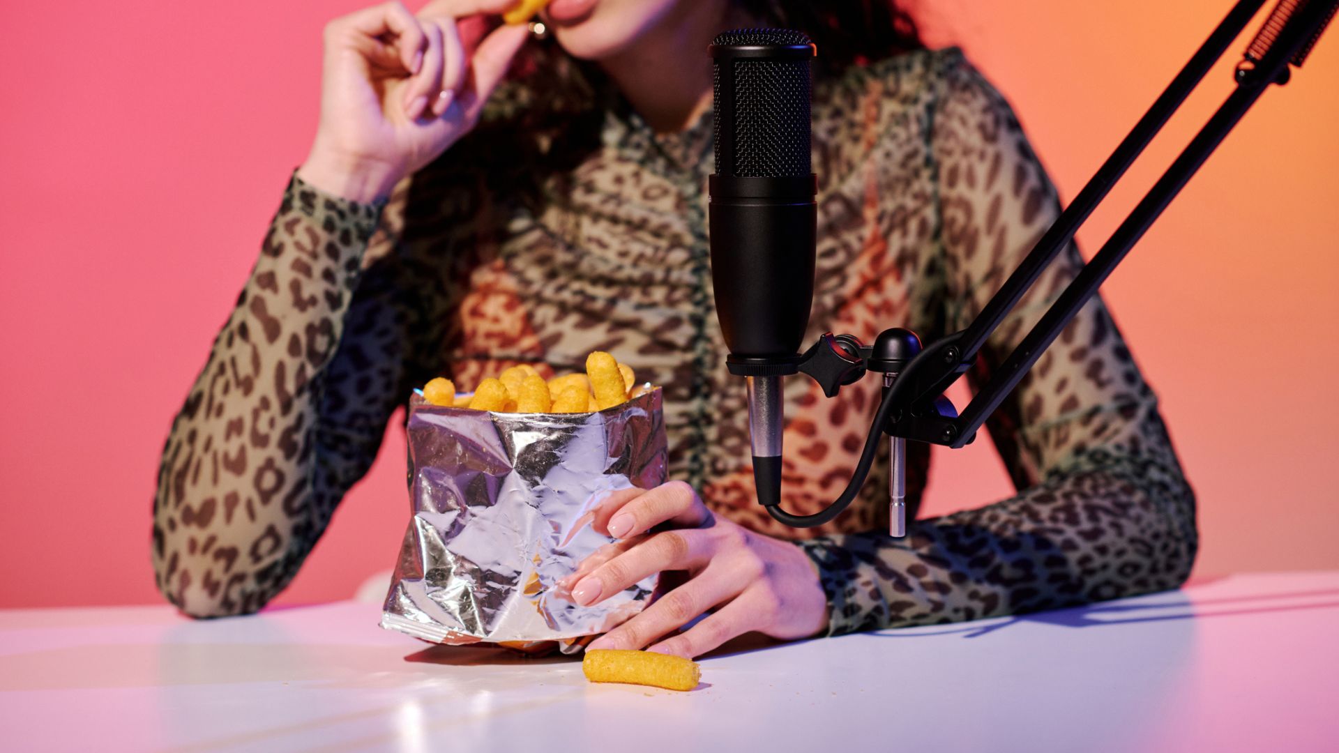 A woman recording ASMR for sleep and eating a bag of crisps into the microphone
