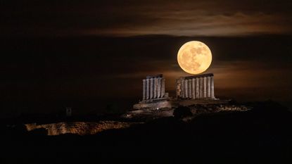 Blue Moon rises over the Temple of Poseidon at Cape Sounion, Greece