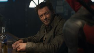 Wolverine (Hugh Jackman) at a bar being approached by Deadpool (Ryan Reynolds) in "Deadpool & Wolverine"