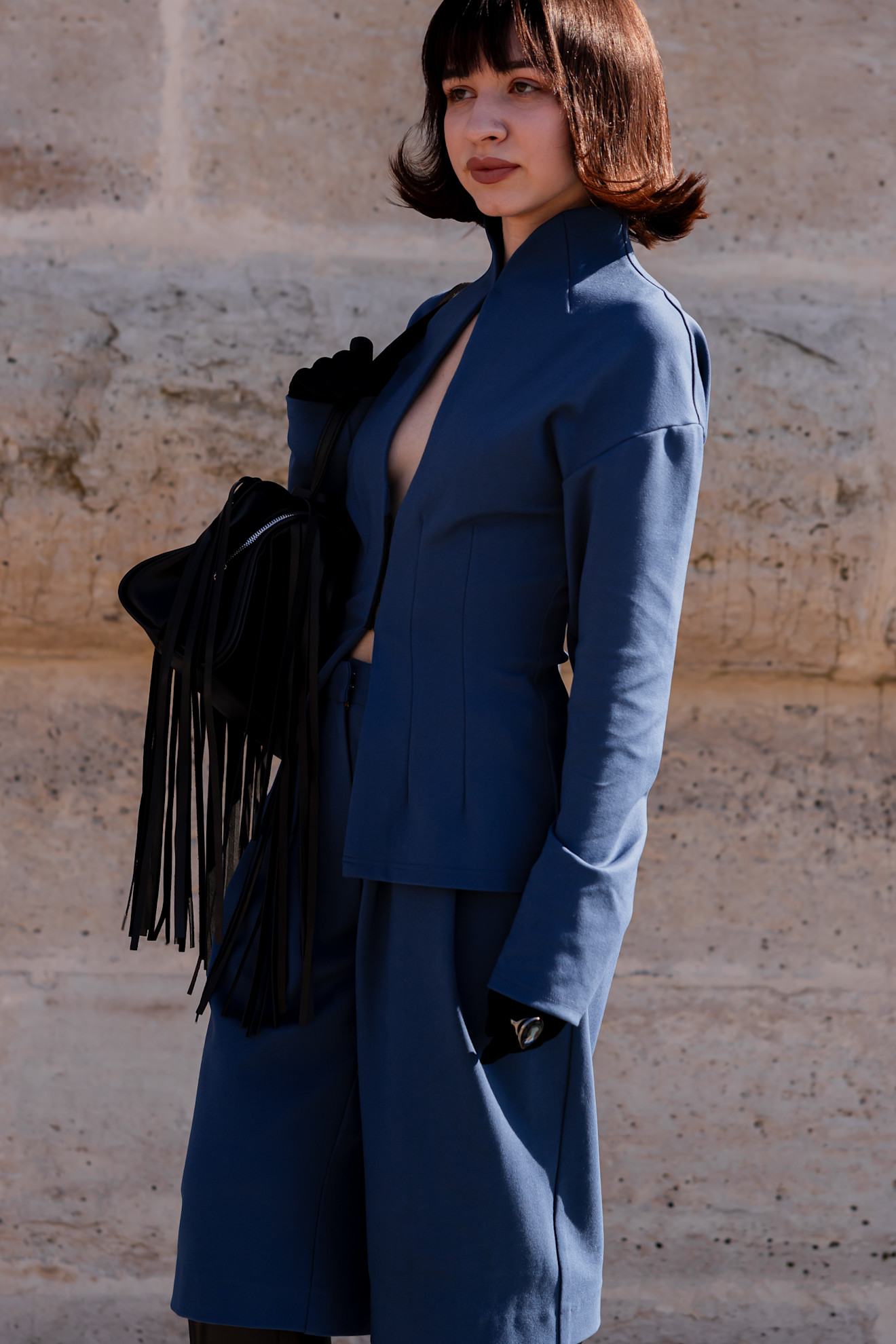 a woman in a blue coat with a fringe bag and a brown flippy bob