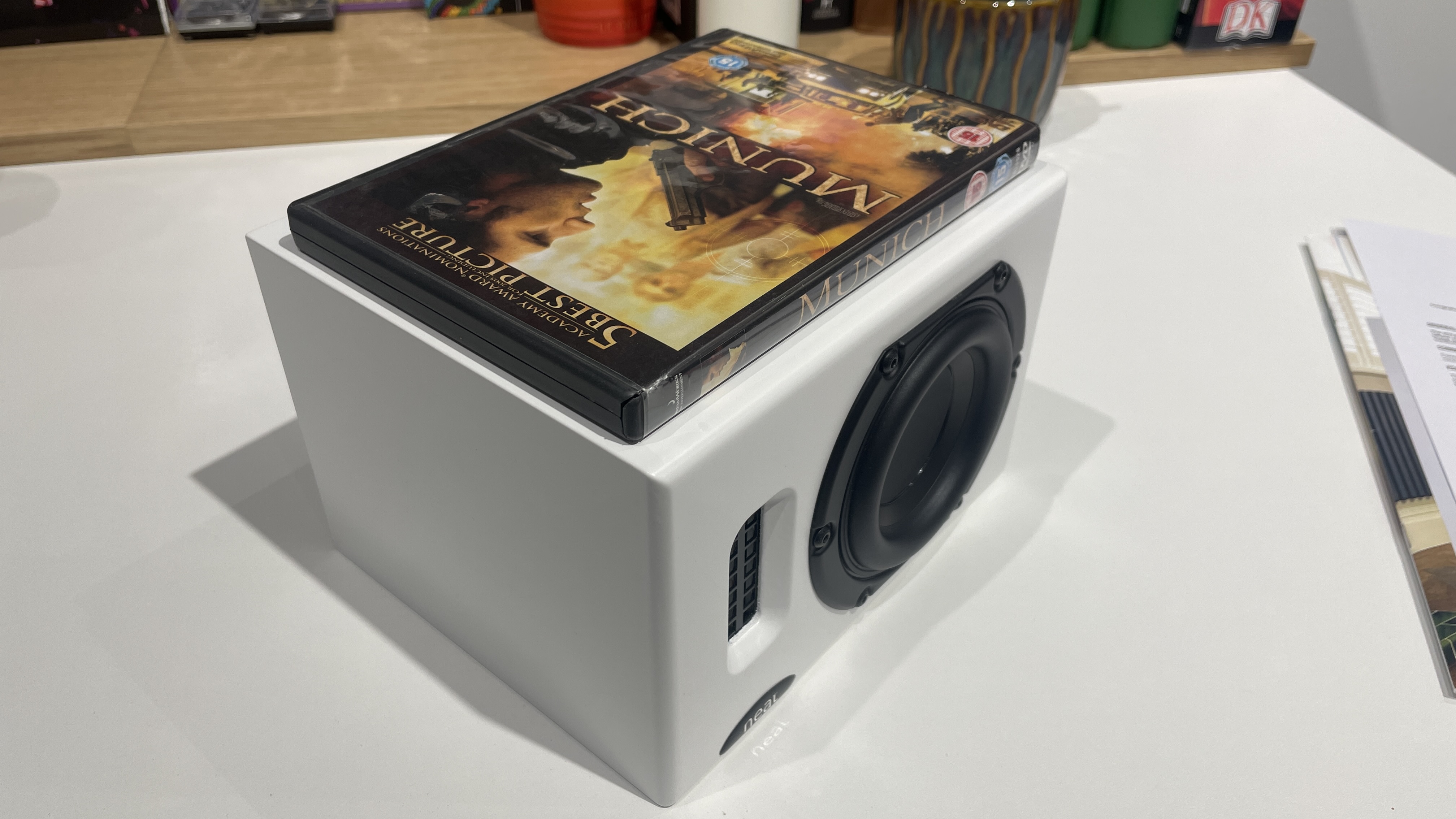 a DVD placed on top of one Neat Iota II speaker