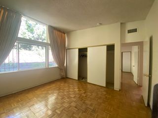 An empty room with parquet flooring and two closet doors