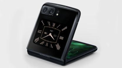 The Motorola Razr 2022 sat half-open with a brown clock face on the secondary display