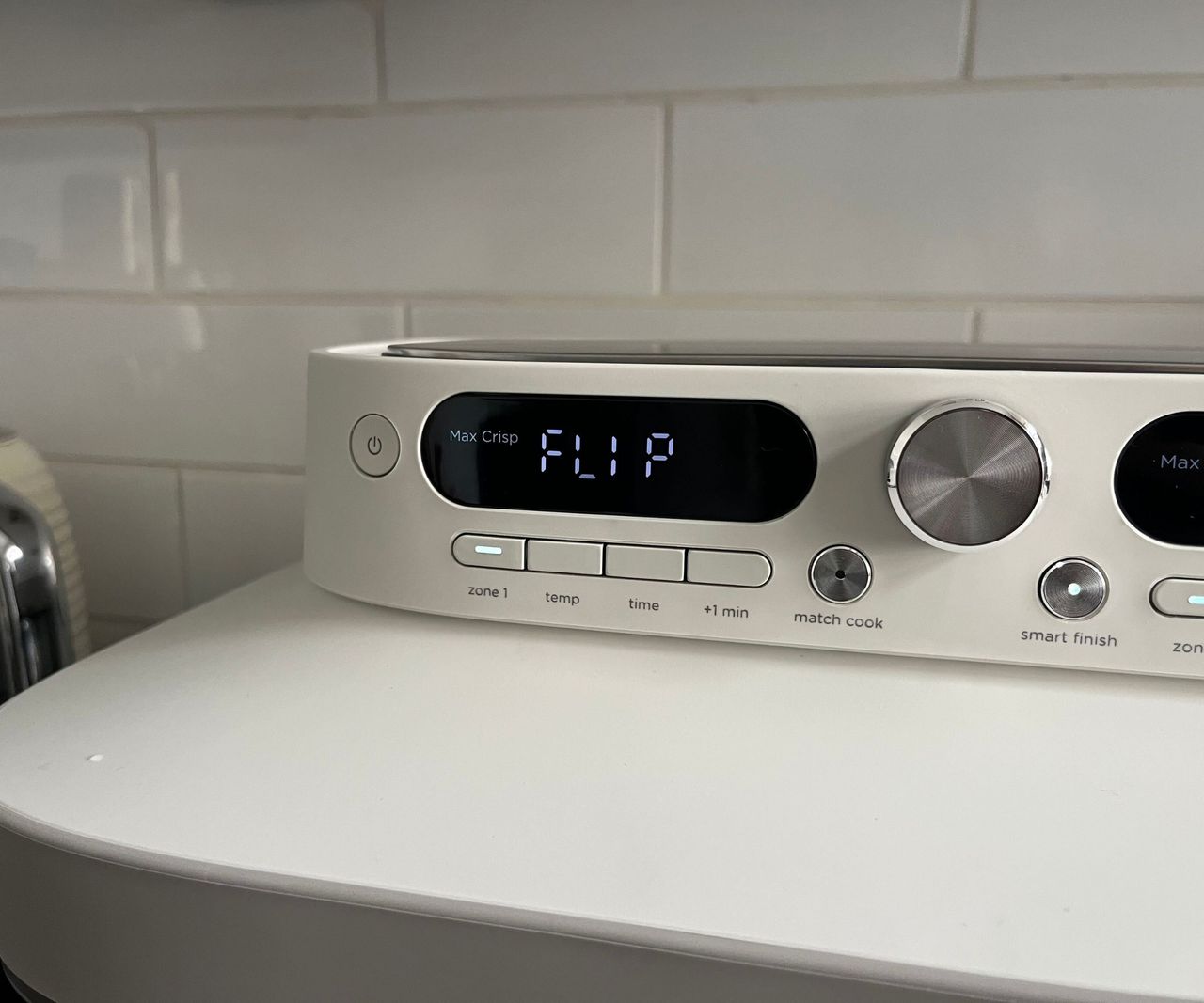 A close up of the Ninja Crispi DualZone air fryer control panel showing the word 'flip'