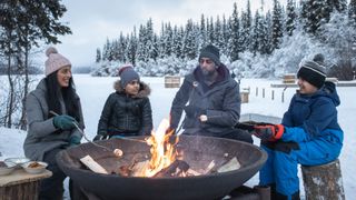 how to build a campfire in winter: family around winter fire