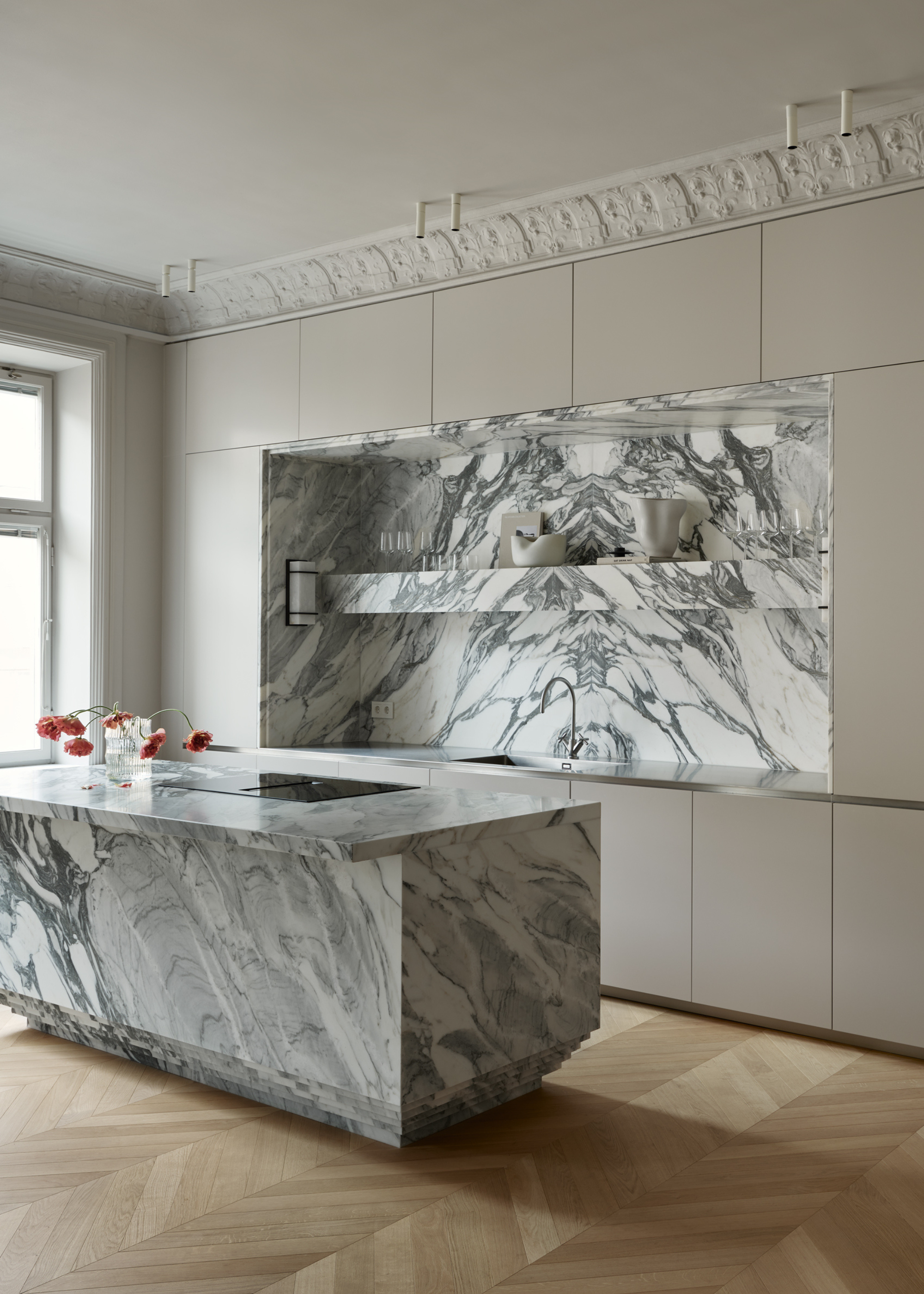 minimalist kitchen with a marble island and matching splashback