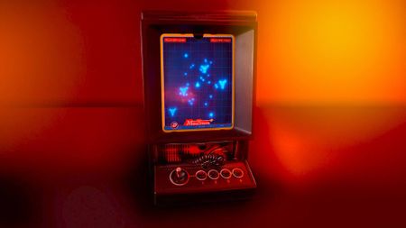 Vectrex Mini console with Minesweeper on screen sitting on orange lit room.