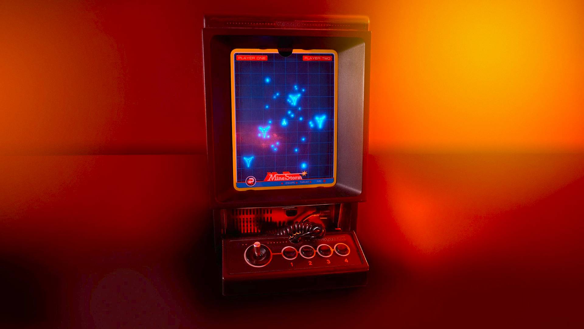 Vectrex Mini console with Minesweeper on screen sitting on orange lit room.