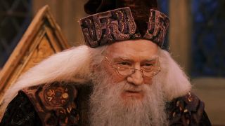 Richard Harris stands smiling in costume while delivering dialogue in Harry Potter and the Sorcerer's Stone.