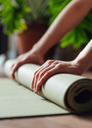 Woman rolling a yoga mat