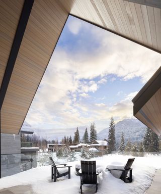 sheltered outside seating area in the snow with view of mountains and trees