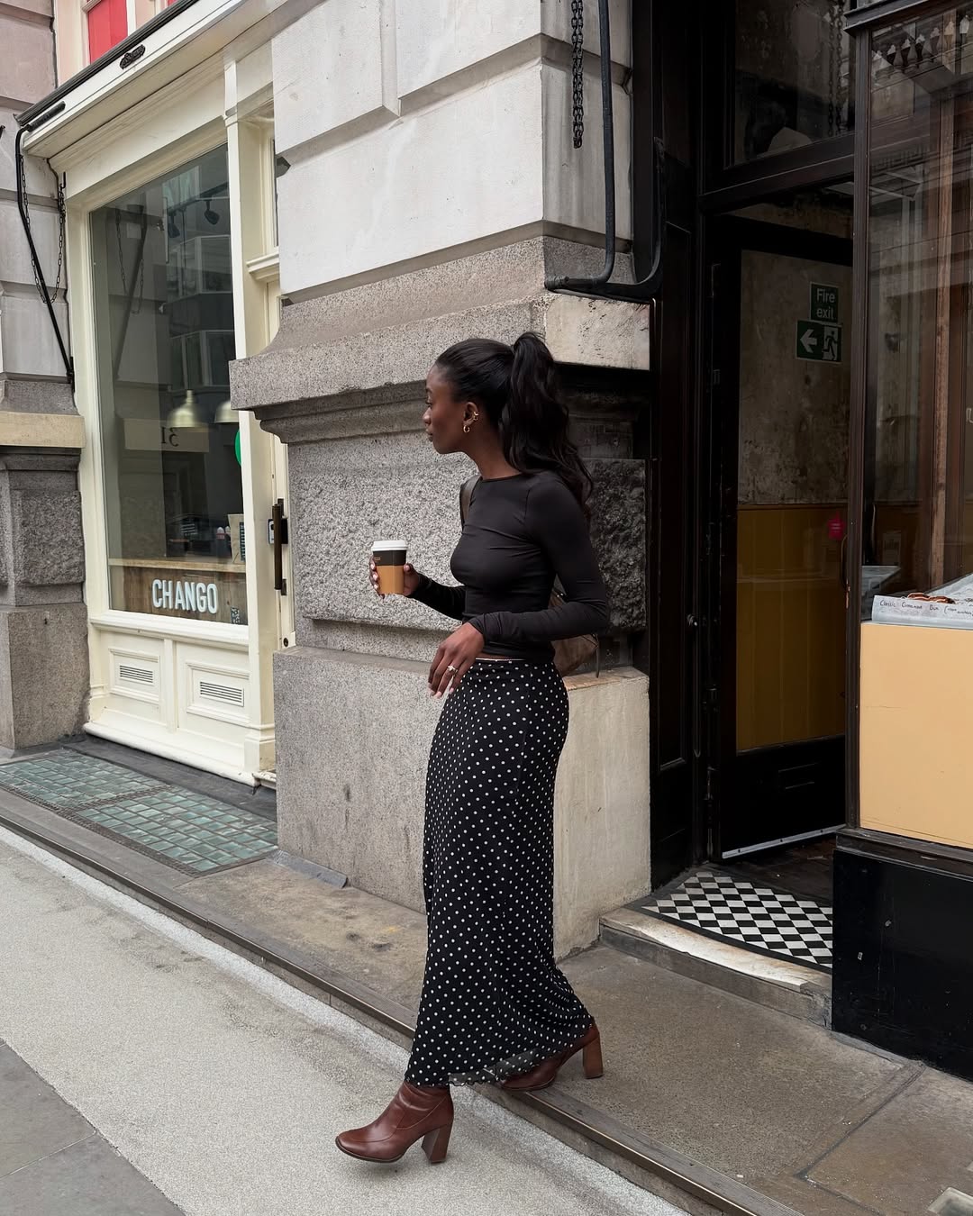 Liv in a polka-dot skirt and long-sleeve black top
