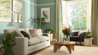 living room with bay window and sage green curtains next to blue wall