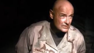 Terry O'Quinn wearing army fatigues against a black background in NCIS