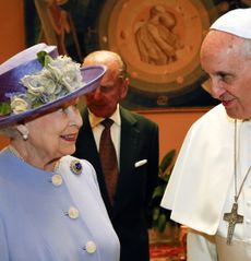Queen Elizabeth wearing a purple coat and hat smiling at Pope Francis