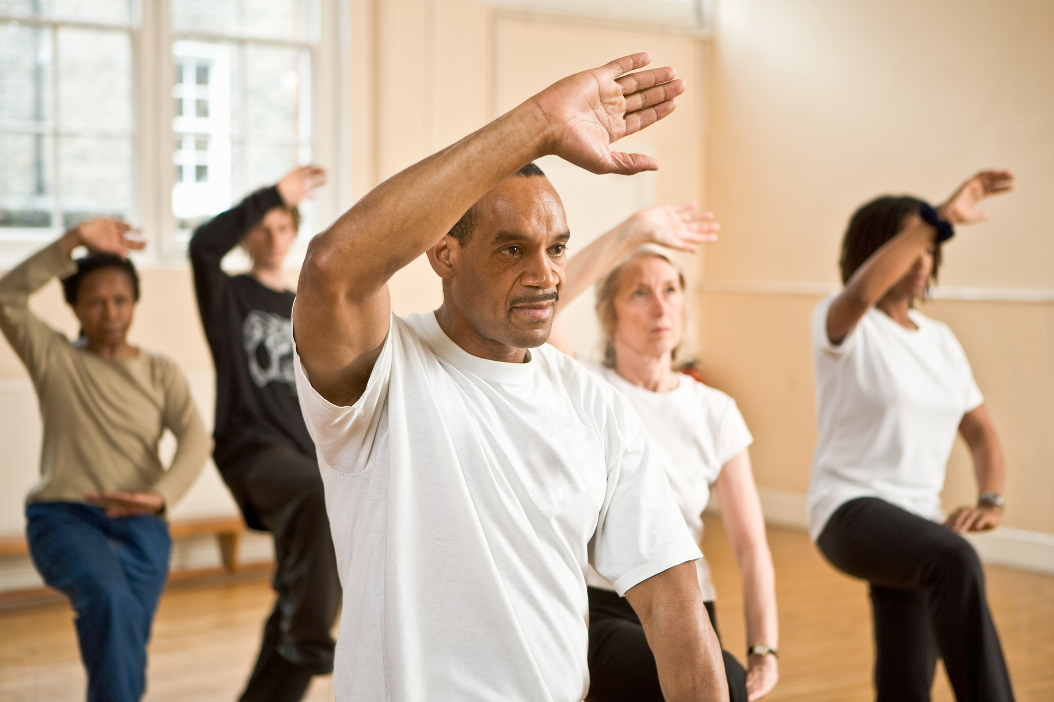 Group of people practicing posture during Tai Chi class.