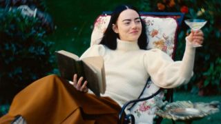 Bella relaxes on a sun lounger with a book and glass of wine in Poor Things, one of the best Disney Plus movies