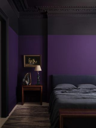 A purple bedroom with a large amethyst crystal on the bedside table