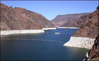 The thick white band ringing Lake Mead’s shoreline shows the drop in water levels. The near-vertical walls of Boulder Canyon are just upstream of Hoover Dam.