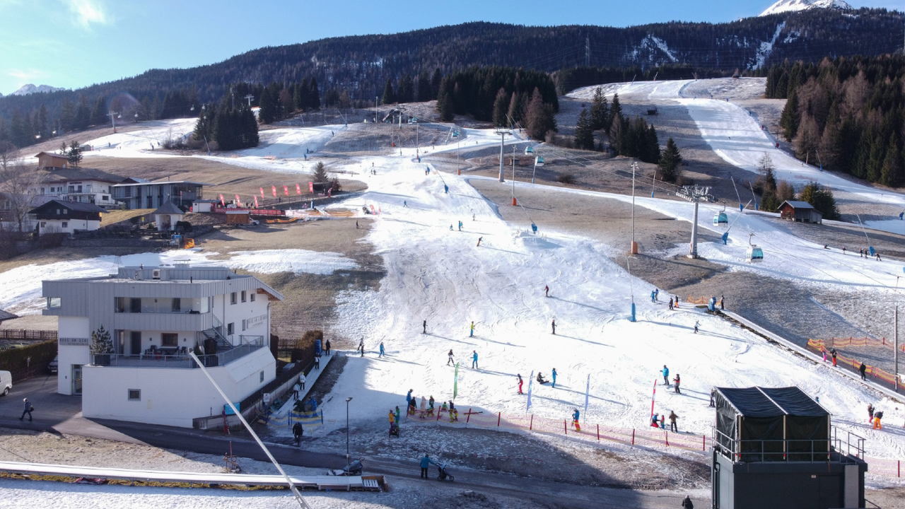 Skiers descend a slope of artificial snow below Grubigstein mountain on January 16, 2023 near Ehrwald, Austria