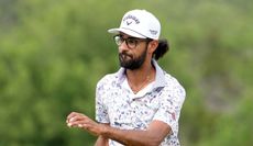 Akshay Bhatia waves to the crowd after holing his birdie putt