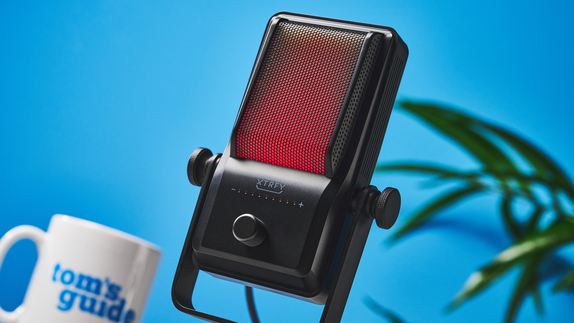 A small retro-inspired microphone with a large RGB sound capsule is photographed against a blue background