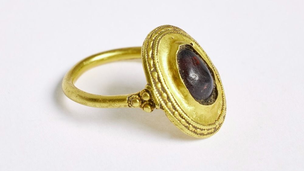 A gold ring with a red stone