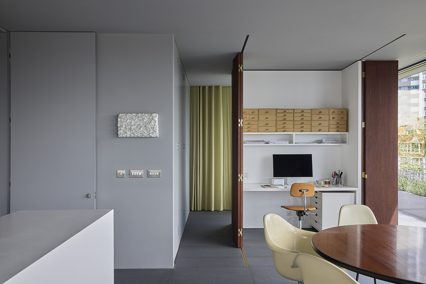 Clerkenwell Rooftop apartment in London, showing minimalist concrete and large openings with terrace and views out to urban views with green