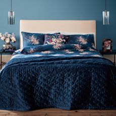 bedroom with blue wall and floral printed blue bedding set