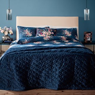 bedroom with blue wall and floral printed blue bedding set