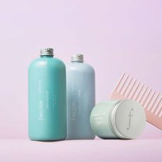 Shampoo & conditioner from Function of Beauty with a pink comb on a lilac background. 