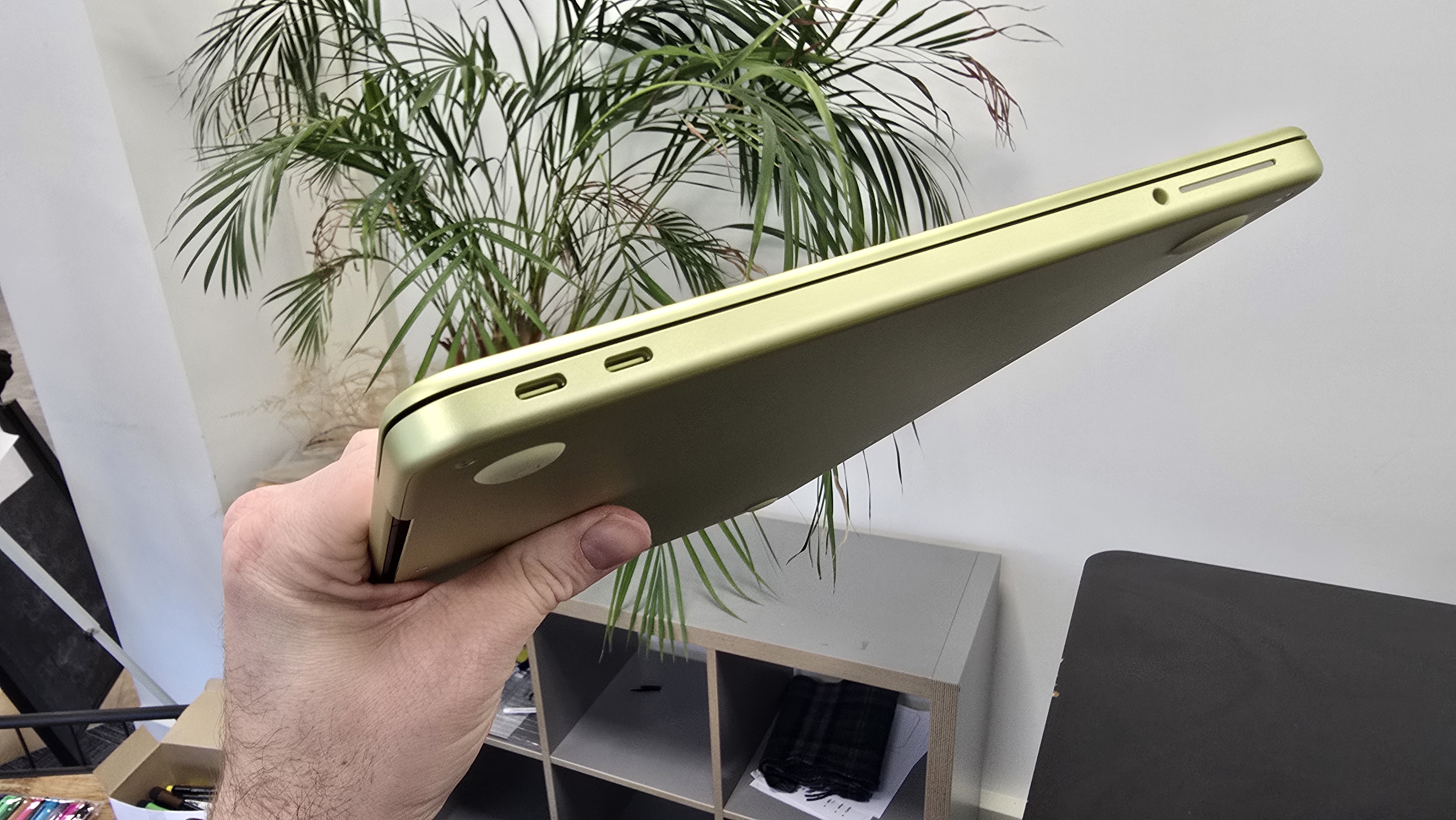 MacBook Neo laptop on a desk with plant in background