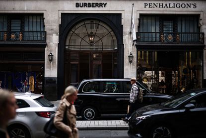 Pedestrians walk past the store of British fashion label Burberry, in central London