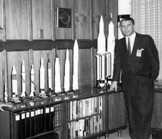 In this photo, probably taken in 1962, Dr. Von Braun is shown in his office at Marshall Space Flight Center with a display of rocket models.